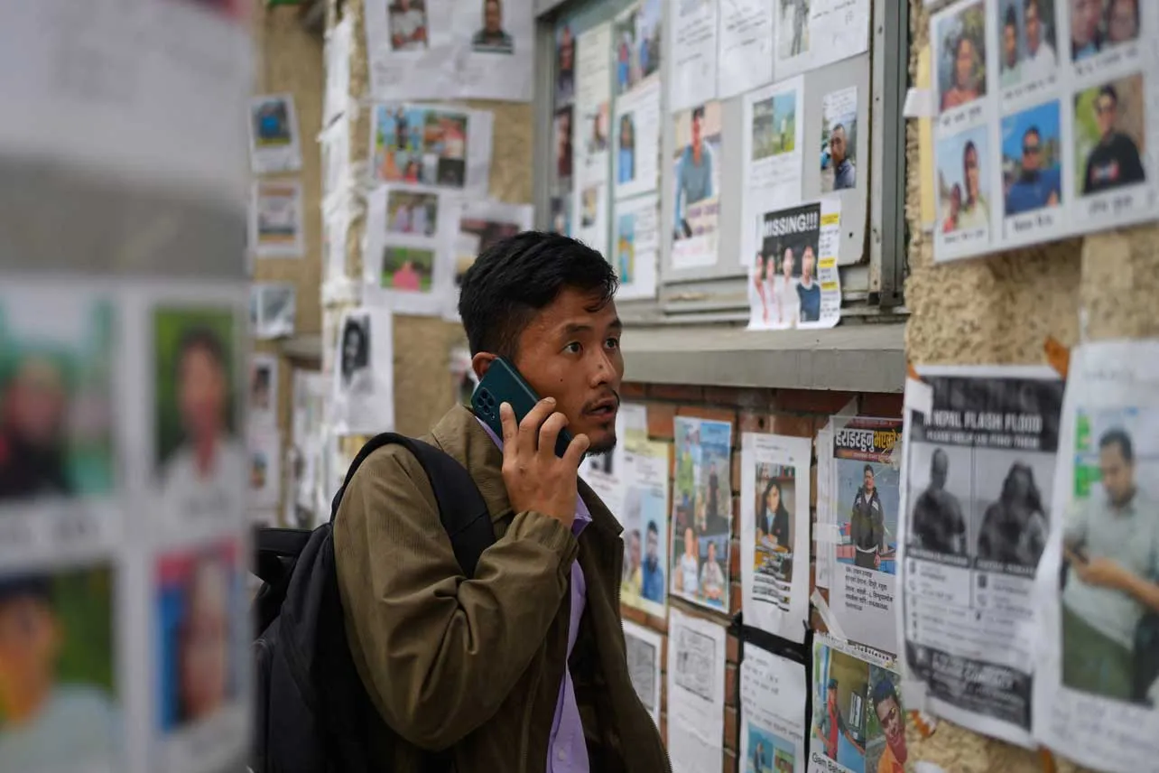 Muro con fotografías de desaparecidos por deslave en Nepal.
