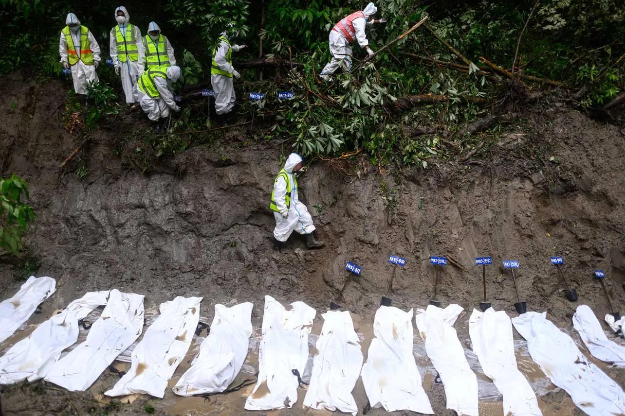 Cuerpos de fallecidos cubiertos con mantas blancas durante el deslave en Nepal 