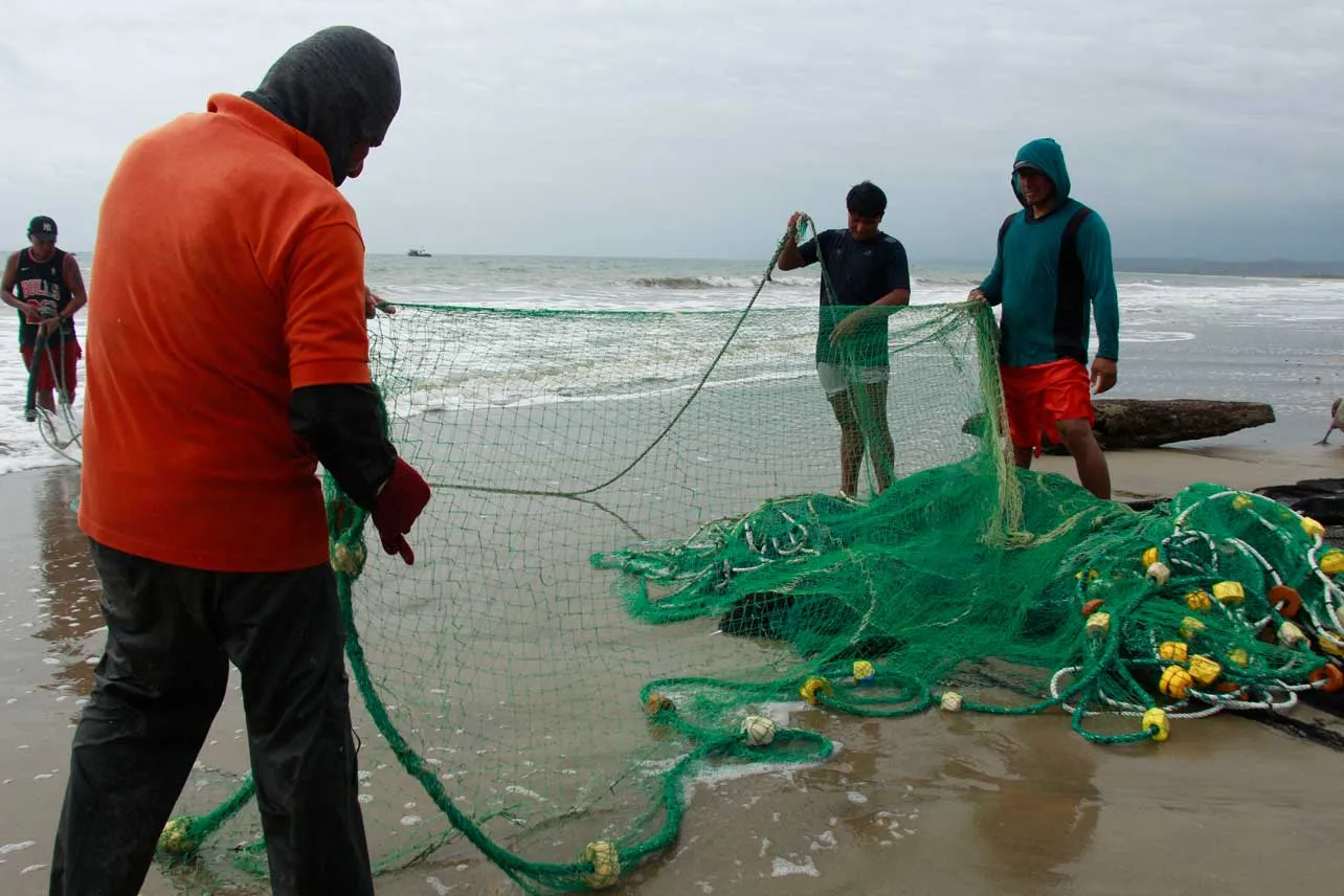 Pescadores con sus redes en la playa.