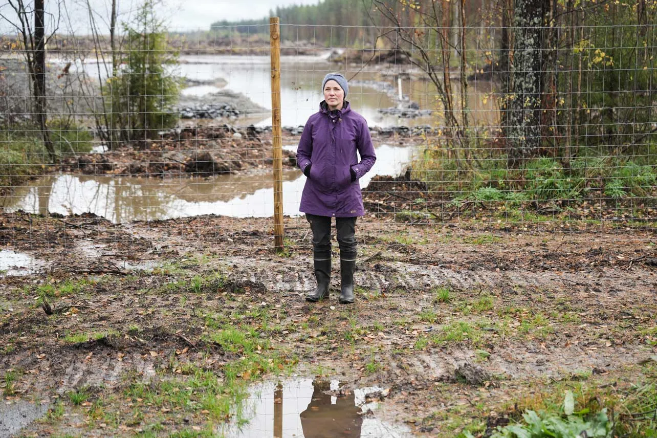 Un mujer frente al terreno cercado donde se construirá un data center de Google en Finlandia.