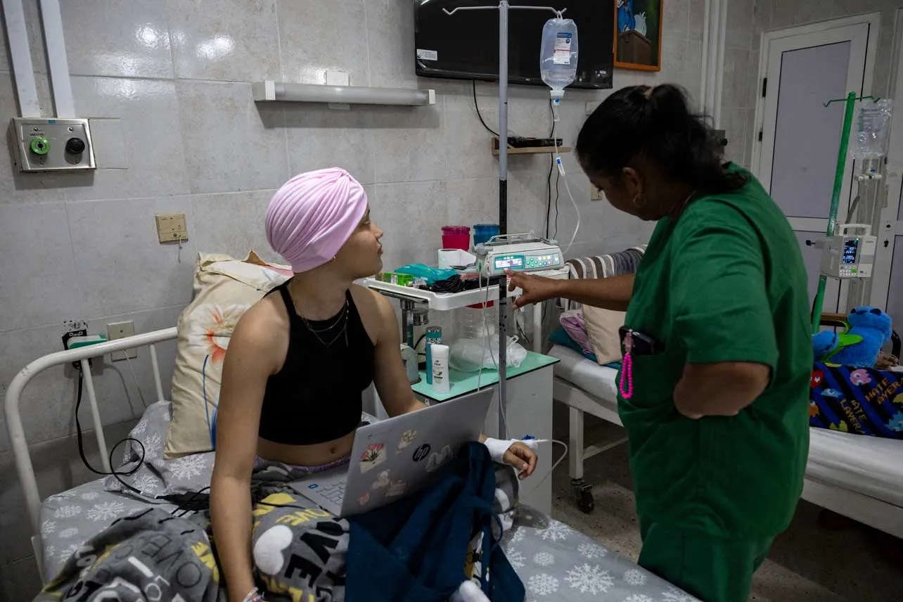 Una paciente con cáncer es atentida por personal sanitario en Cuba.