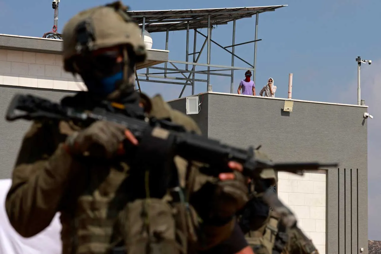 Un soldado israelí en la entrada a una de las colonias de israelíes cercanas al límite con Cisjordania.
