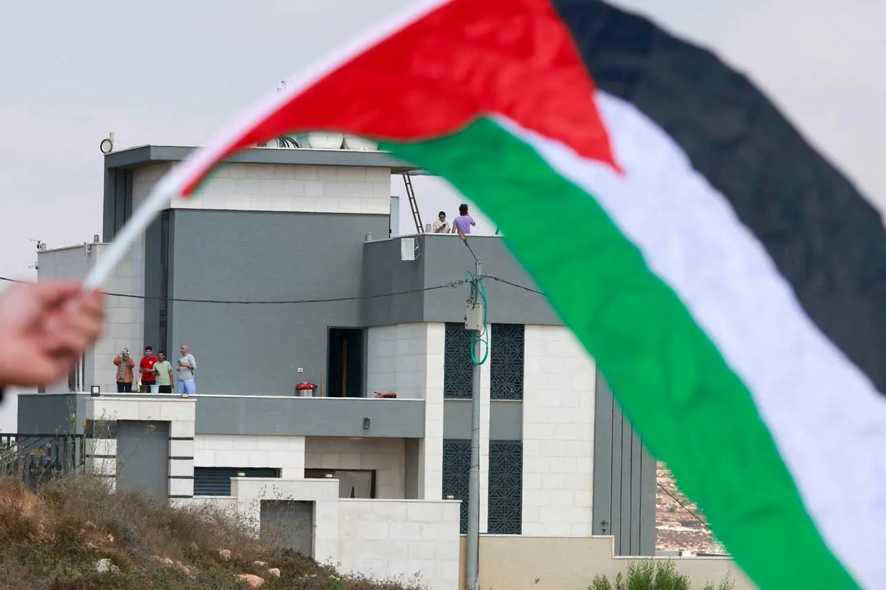 Bandera palestina, al fondo se ve una colonia israelí cerca de Cisjordania.