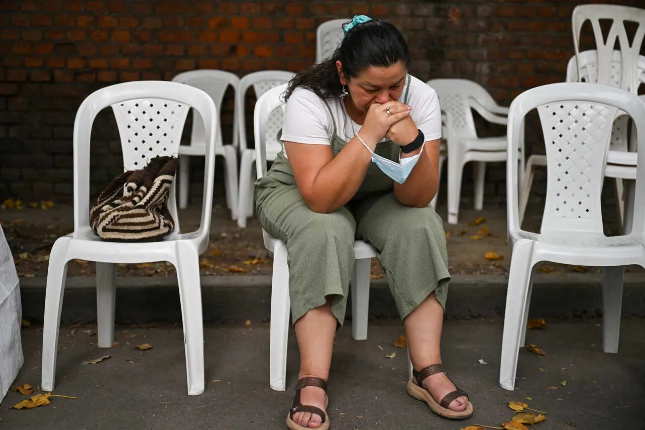 Mujer pensativa sentada en una silla.