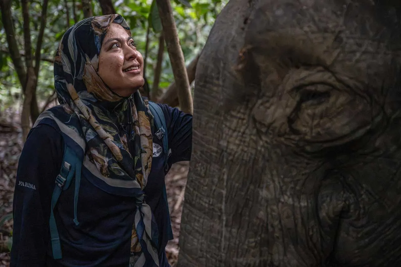 Conservacionista Farina Othman junto a un elefante en Borneo.