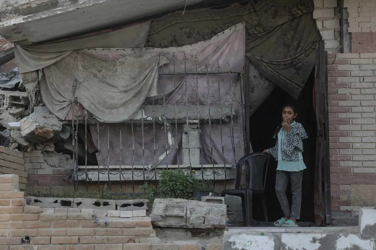 Una niña en la entrada de un edificio en ruinas en Gaza.