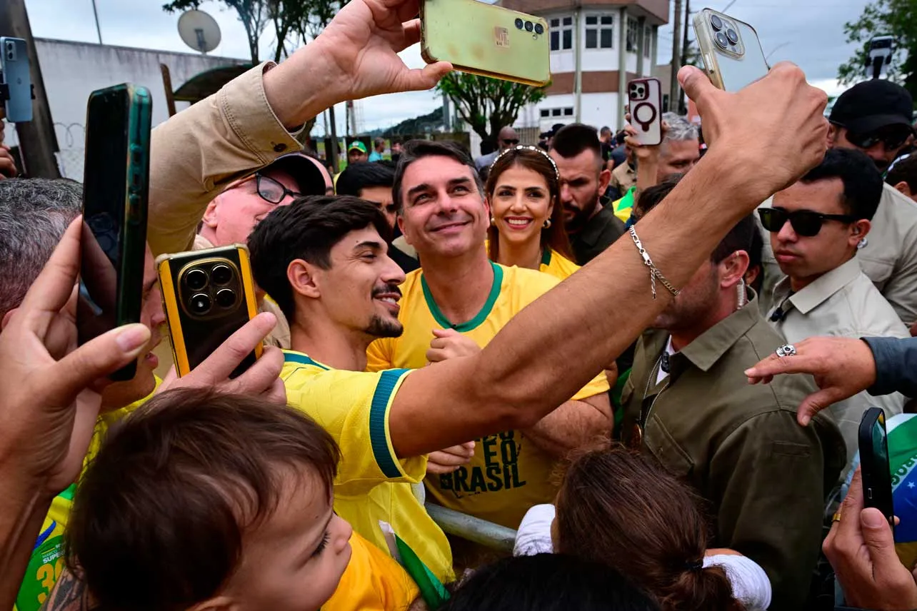 Candidato Flávio Bolsonaro se toma foto con un simpatizante.