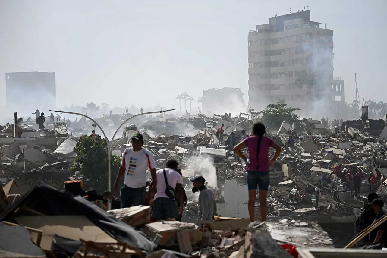 Personas miran escombros que dejó terremotos en Venezuela.
